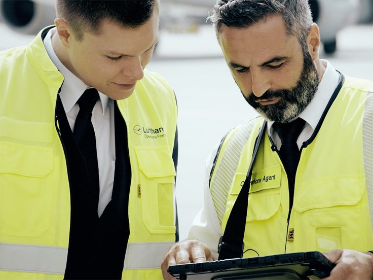 Two men looking at a tablet