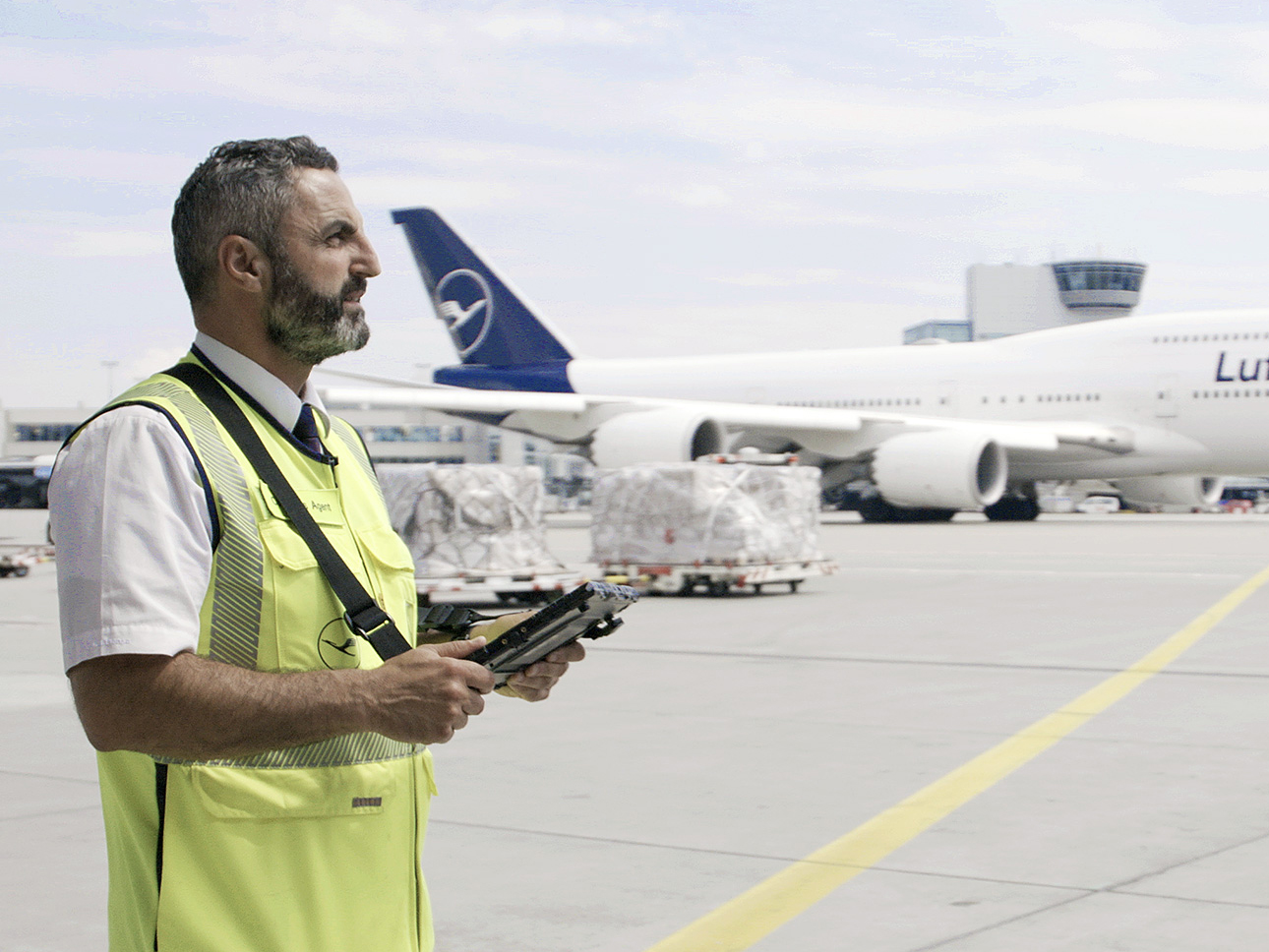 A Lufthansa employee stands on an airfield