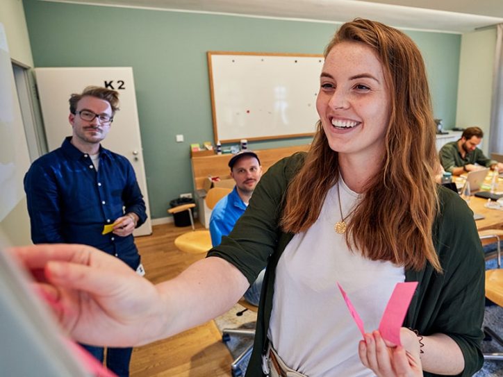 Woman standing at whiteboard to prepare PKV digital health platform