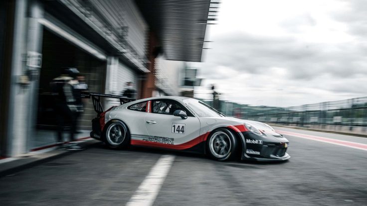 Porsche stands on the sidelines of a racetrack