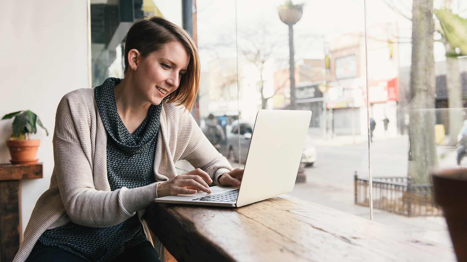 Frau arbeitet an ihrem Laptop in einem Café
