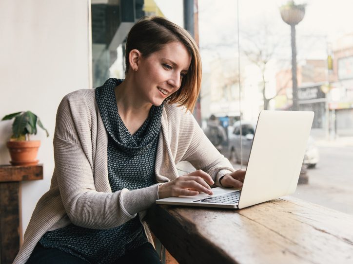 Women working on laptop at a coffee table in a café