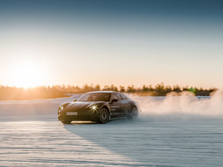 A Porsche driving through a snowy landscape.