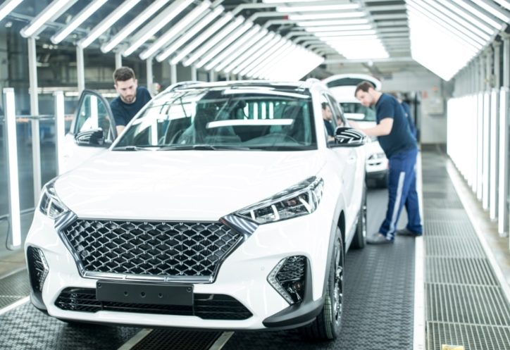 People working on a car, representing why the industry is undergoing a triple transformation in the process of digitalization