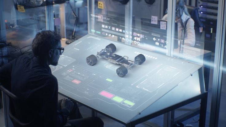 Engineer working at a futuristic digital interface, analyzing a 3D model of a vehicle chassis in a high-tech design lab.